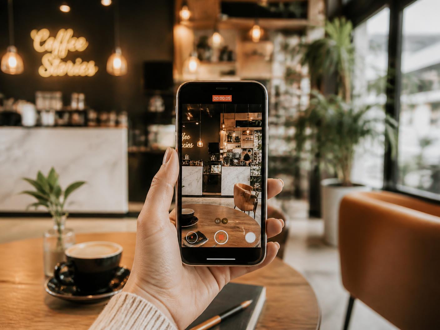 Telefon der filmer et cafémiljø til sociale medier